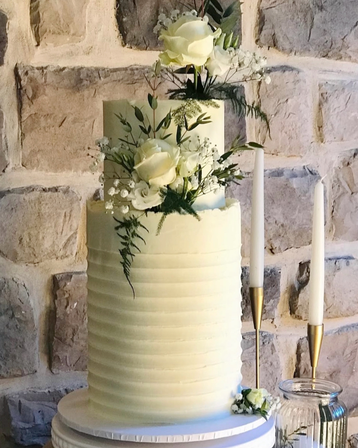 All white double barrel wedding cake with fresh white roses and gypsophila