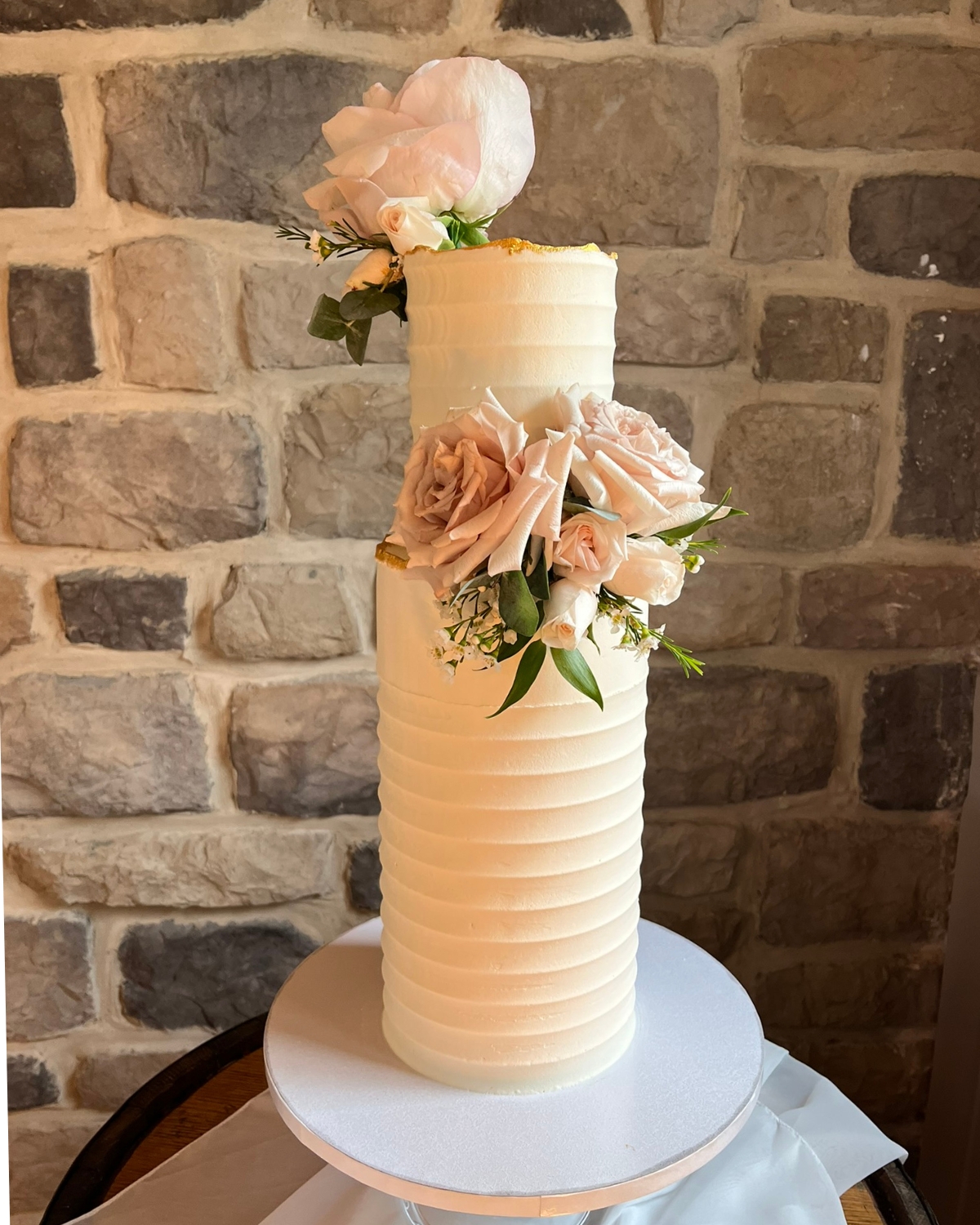 Double barrel wedding cake in blush and gold with soft pink roses