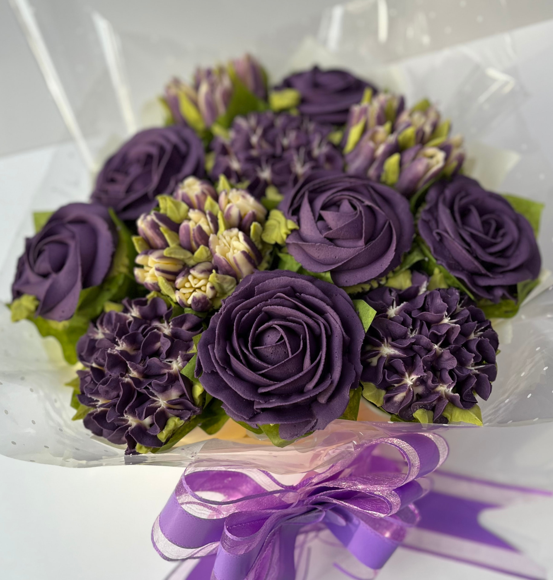 Classic 12-cupcake bouquet in deep purple buttercream roses and hydrangeas