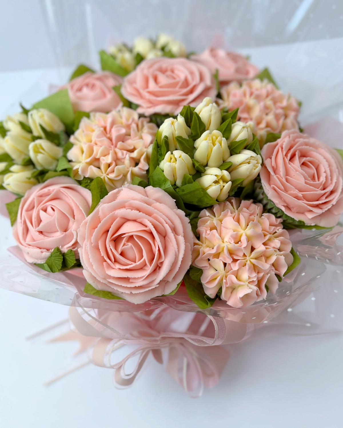 Classic 12-cupcake bouquet in pale pink buttercream roses and cream tulips