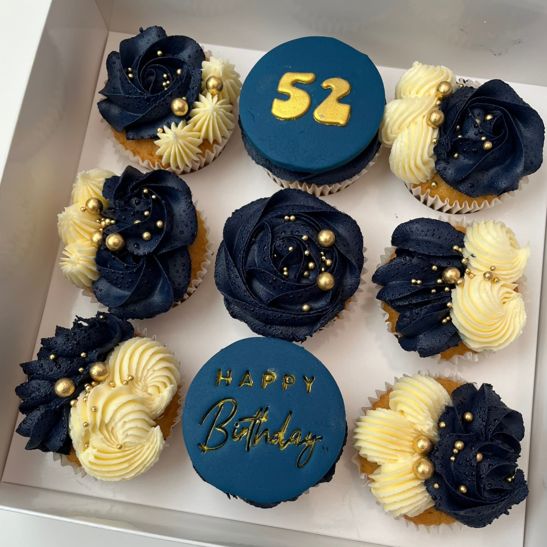 Navy and cream birthday cupcakes with gold pearls and fondant toppers