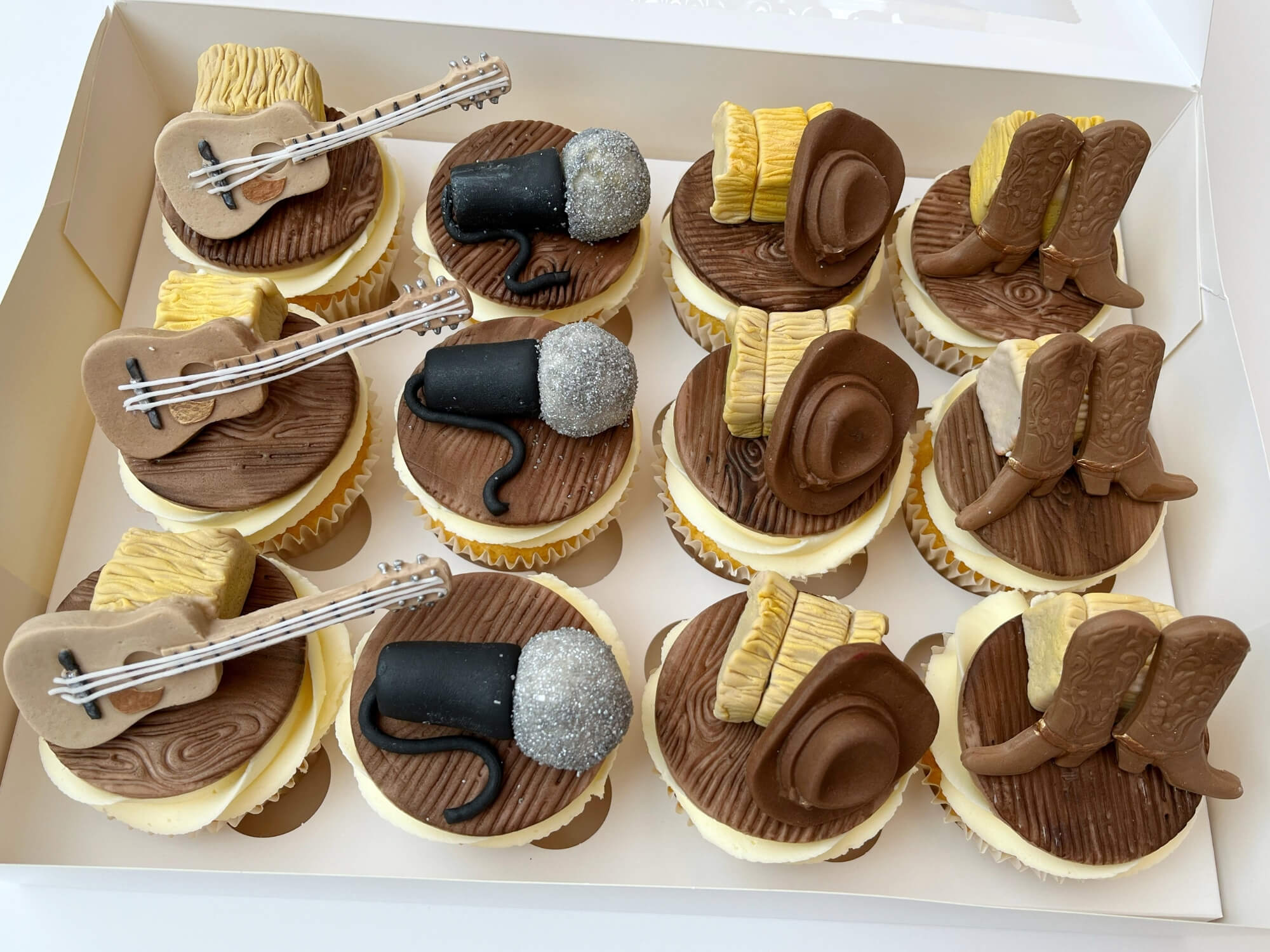 Country and western cupcakes with sugar guitars, cowboy hats and boots
