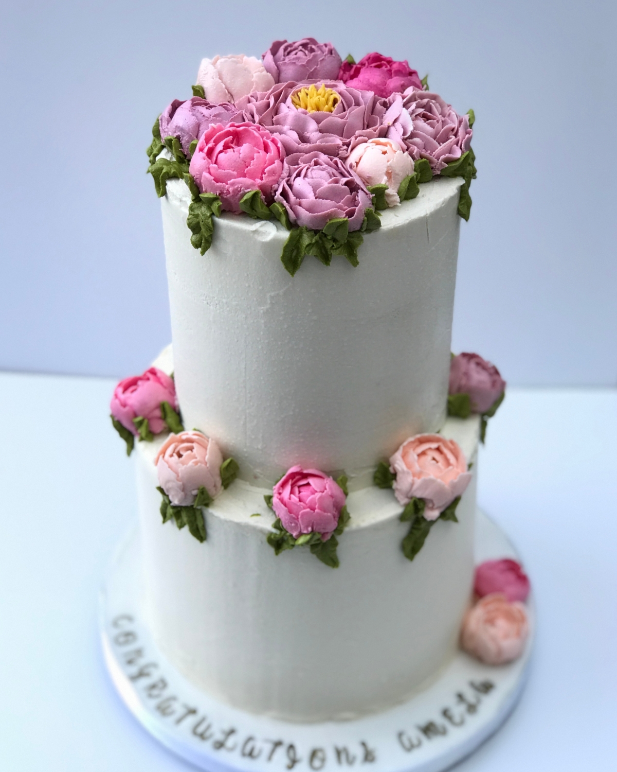 Two tier white ganache cake with hand-piped buttercream peonies