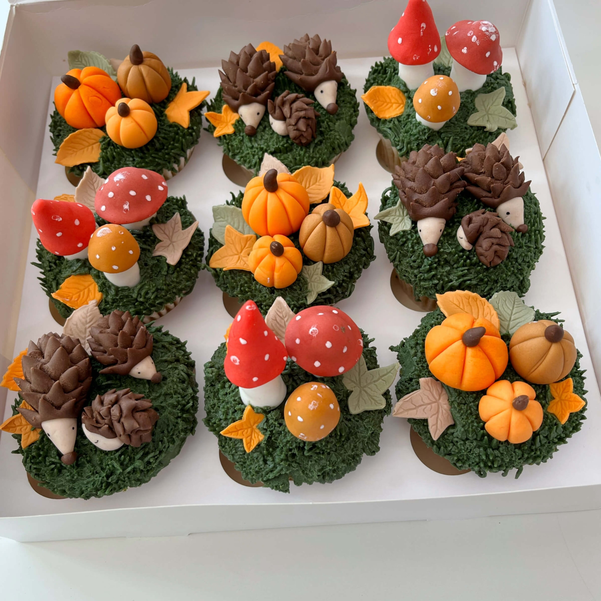 Autumnal cupcakes with sugar pumpkins, toadstools and hedgehogs